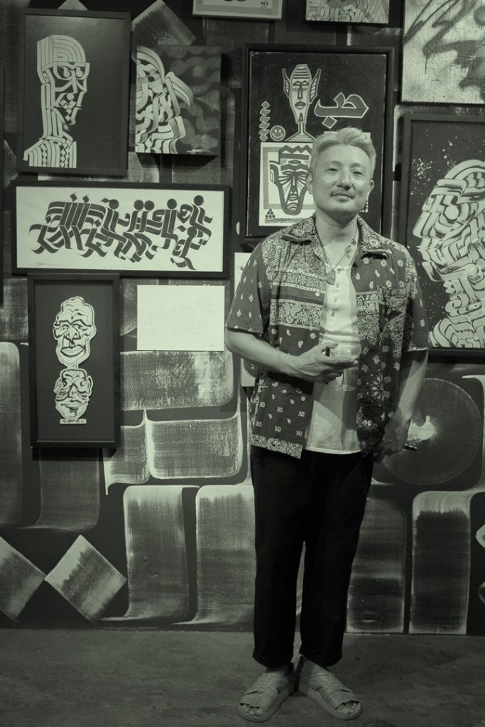 Guest in front of artworks at the Rostarr opening exhibition in Room 13 at The Slow